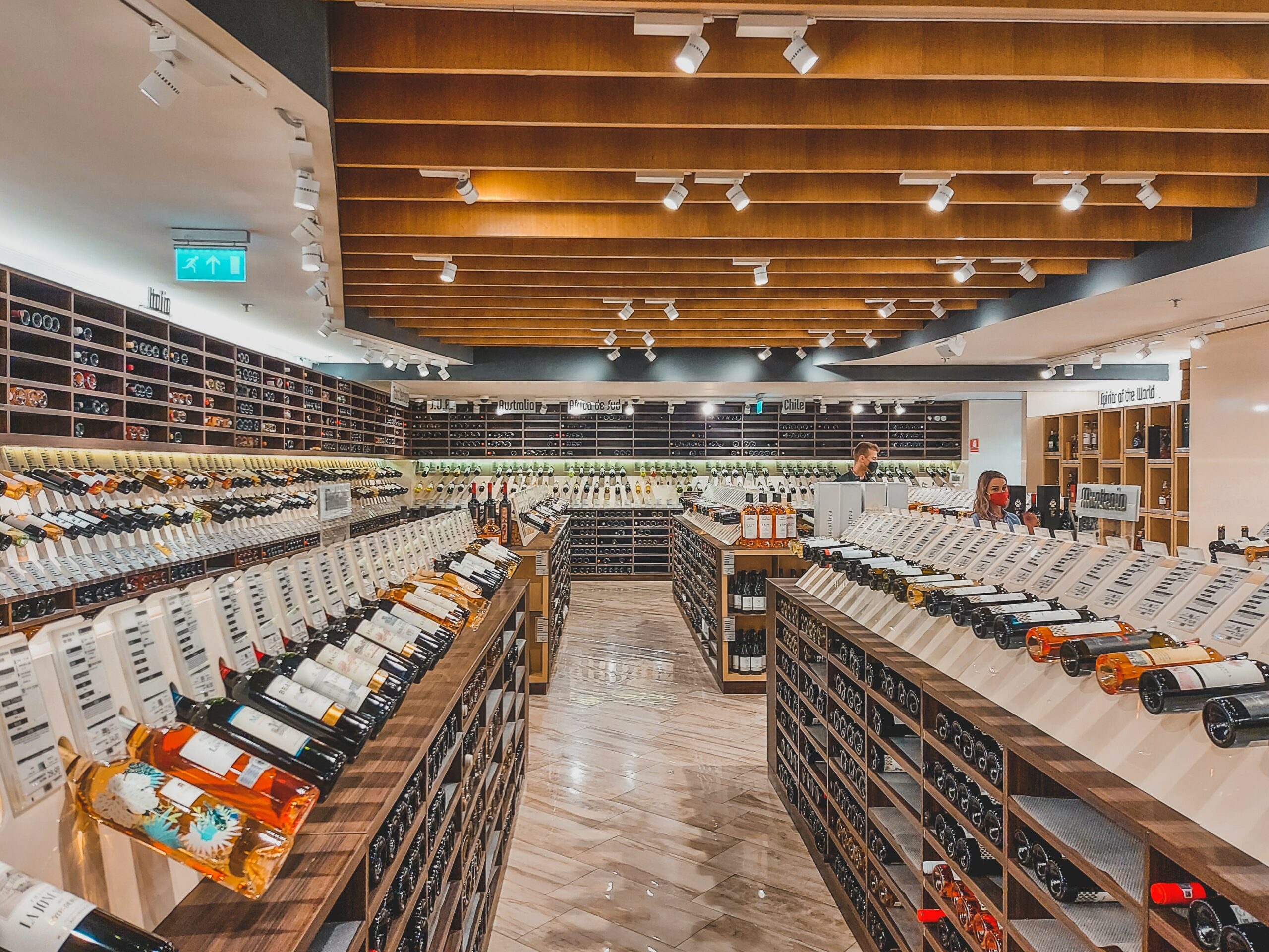 a large selection of wine on shelves in a liquor store | west roxbury wine store